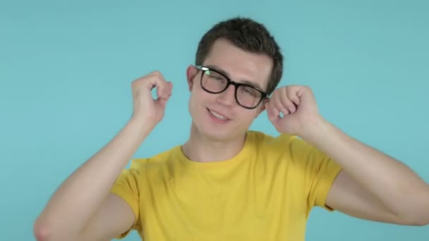 Счастливый молодой человек танцует на голубом фоне — стоковое видео