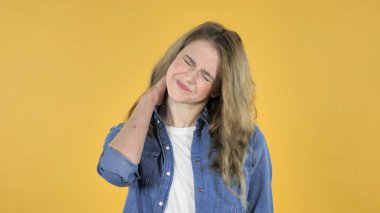 Genç güzel kız ile boyun ağrısı, sarı arka plan