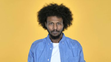 Casual Afrika adam sarı arka plan üzerinde izole kamera bakıyor