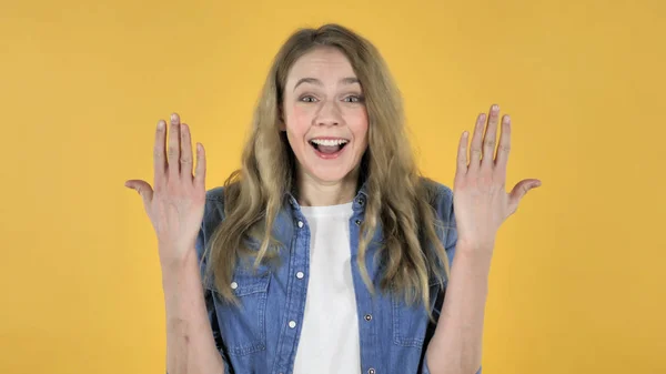 Menina bonita nova em choque no fundo amarelo, querendo saber — Fotografia de Stock