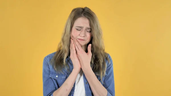 Dolor de muelas, joven chica bonita con dolor de dientes sobre fondo amarillo — Foto de Stock