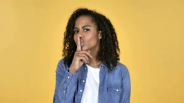 African Girl Gesturing Silence, Finger on Lips, Yellow Background — Stock Photo, Image