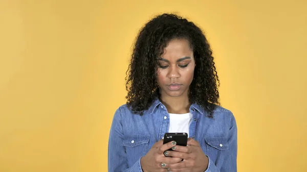 아프리카 소녀 노란색 배경에 고립 된 스마트폰 검색 — 스톡 사진