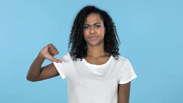 Africano menina gesturing polegares para baixo isolado no fundo azul — Fotografia de Stock