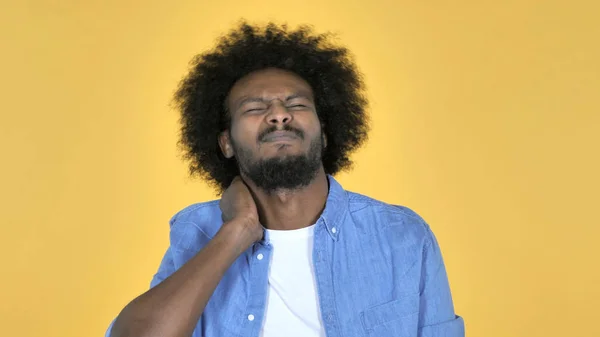 Hombre africano casual con dolor de cuello, fondo amarillo —  Fotos de Stock