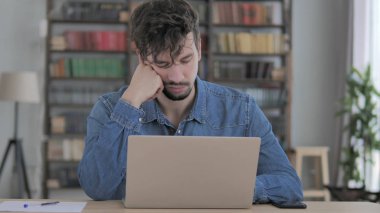 Dizüstü bilgisayarda çalışırken yorgun adam uyuyor