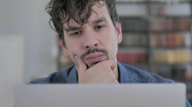 Bir dizüstü bilgisayarda çalışırken düşünme dalgın adam yakın çekim