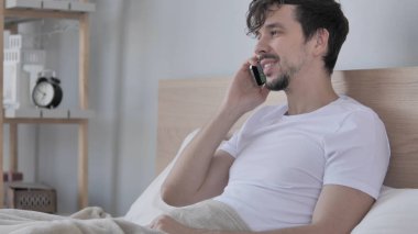 Adam Talking Lying yatakta tarafında ise telefon