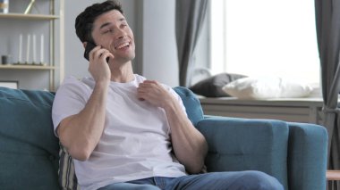 Kanepede Otururken Gündelik Genç adam Telefonda Konuşuyor