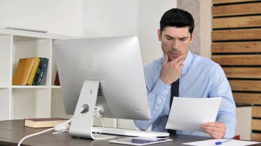 Düşünceli Genç İşadamı İş Yerinde Belgeleri Okuma, Düşünme