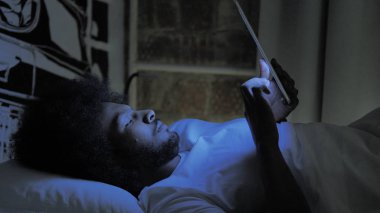 Afrikalı Adam Gece Yatakta Tablet Kullanma