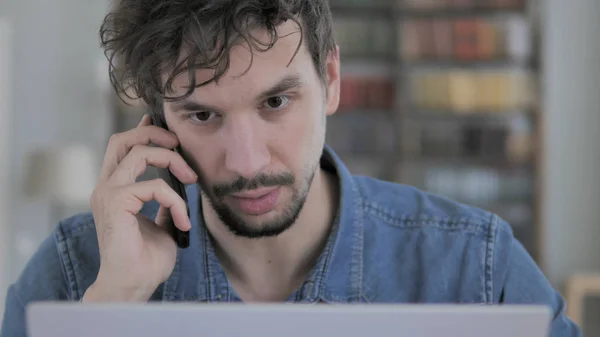 Negoziazione da parte di Casual Young Man mentre parla al telefono — Foto Stock