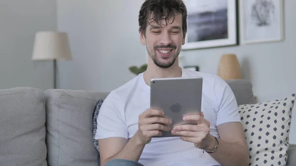 Tablet rahat genç adam kanepede rahatlatıcı tarafından online görüntülü sohbet — Stok fotoğraf