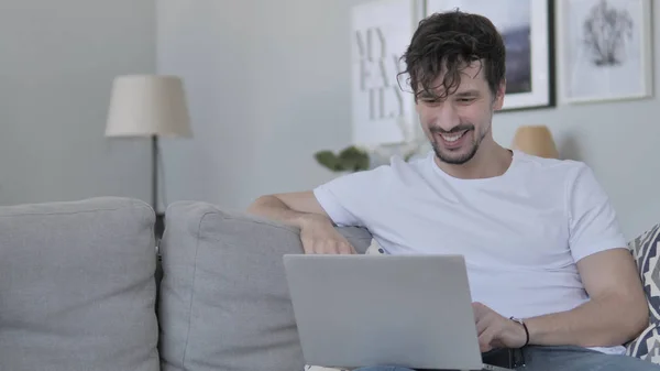 Онлайн видео чат на ноутбуке, расслабляя молодого человека — стоковое фото