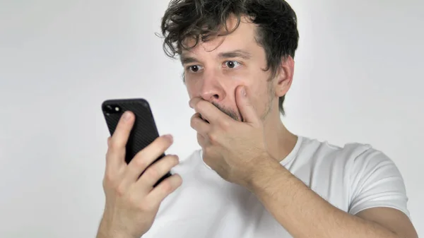 Молодий випадковий чоловік у шоці під час використання смартфона — стокове фото