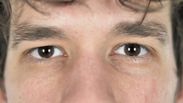 Primer plano de los ojos parpadeantes de un joven hombre casual — Foto de Stock