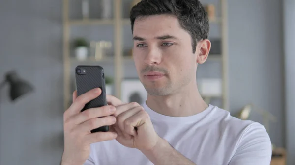 Portrait de jeune homme occupé à utiliser un smartphone — Photo