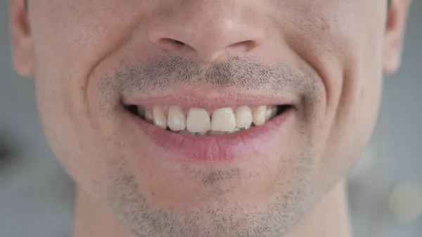 Gros plan sur les lèvres souriantes et les dents du jeune homme — Photo