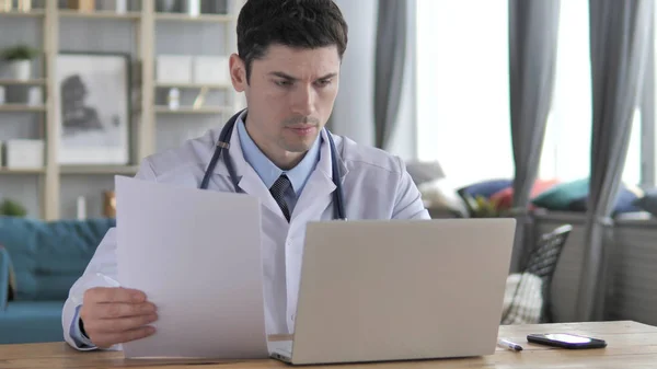 Médico trabajando en informe médico y computadora portátil —  Fotos de Stock