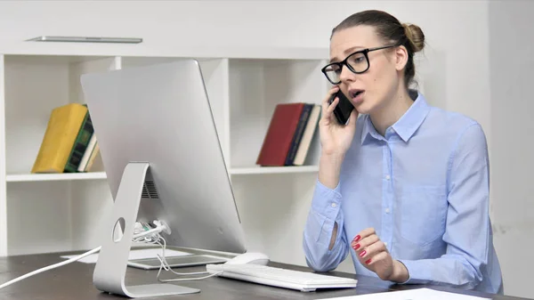 Jonge vrouw praten op telefoon en het gebruik van computer — Stockfoto