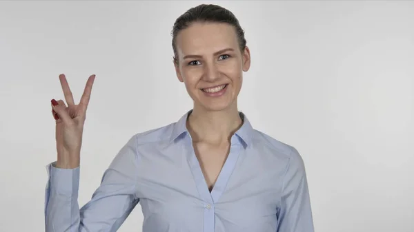Junge Geschäftsfrau gestikuliert Siegeszeichen auf weißem Hintergrund — Stockfoto