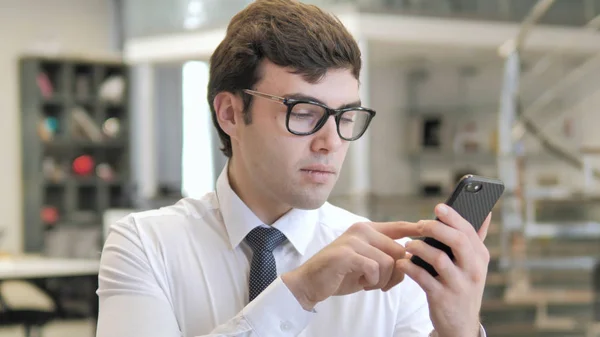 Mladý podnikatel používající telefon Smartphone, zadávání zpráv — Stock fotografie