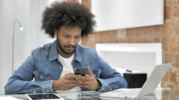 African Man korzystanie Smartphone w Loft Office — Zdjęcie stockowe
