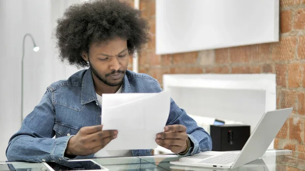 African Man czytanie dokumentów w pracy — Zdjęcie stockowe