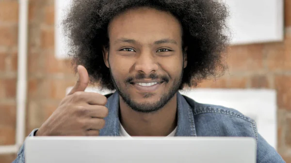 Polegares para cima pelo homem africano que trabalha no portátil — Fotografia de Stock