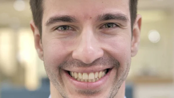 Lähikuva hymyilevä nuori mies kasvot — kuvapankkivalokuva