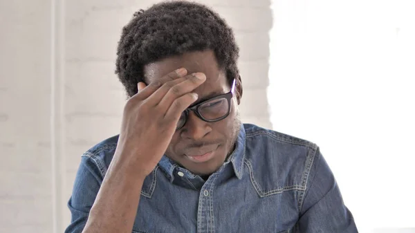 Dor de cabeça, homem africano estressado no trabalho — Fotografia de Stock