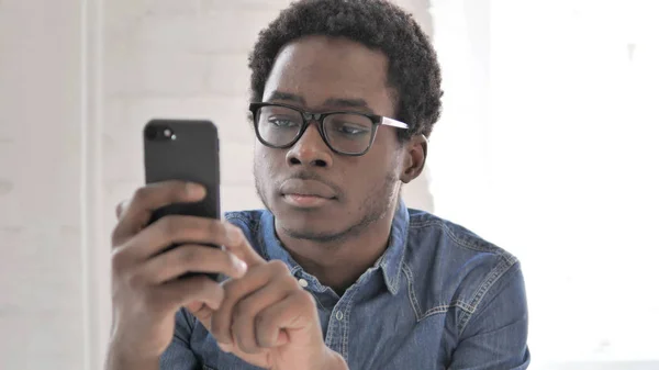 Homem Africano ocupado mensagens de texto no Smartphone — Fotografia de Stock