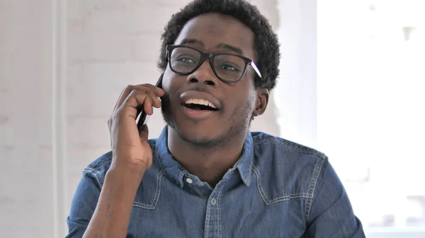Afrikansk man pratar på telefon och diskuterar arbete — Stockfoto