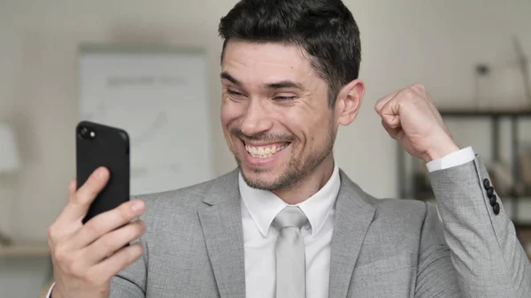 Businessman Excited for Success on Smartphone