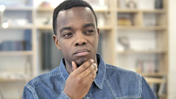 Pensive jonge Afrikaanse man denken een idee — Stockfoto