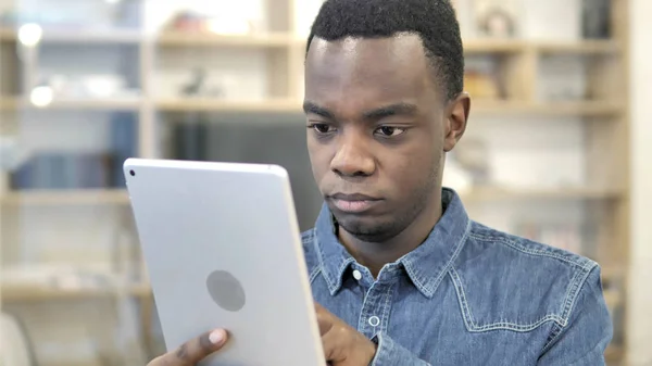 Ung afrikansk man surfar på Tablet — Stockfoto