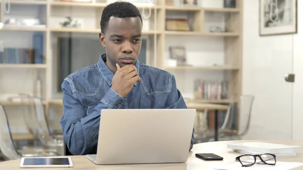 Pensando jovem homem africano trabalhando no laptop — Fotografia de Stock