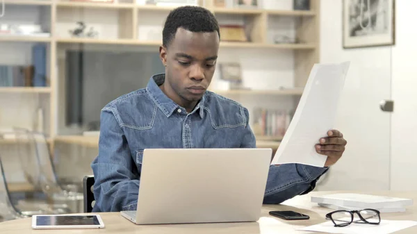 Ung afrikansk man gör pappersarbete i Office — Stockfoto