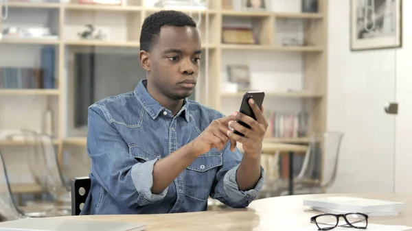 스마트 폰을 사용하는 젊은 아프리카 남자, 문자 메시지 — 스톡 사진