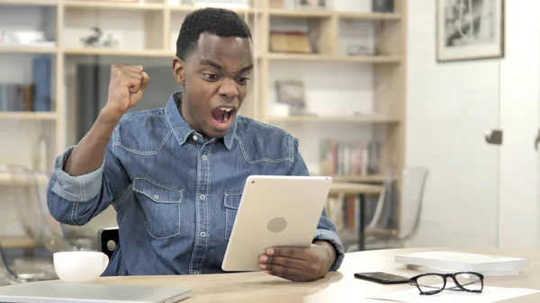 Man Celebrating Success while Using Tablet