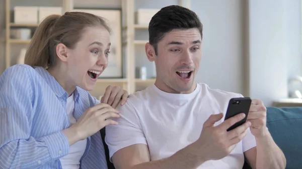 Young Couple Excited for Success while Using Smartphone — Stock Photo, Image