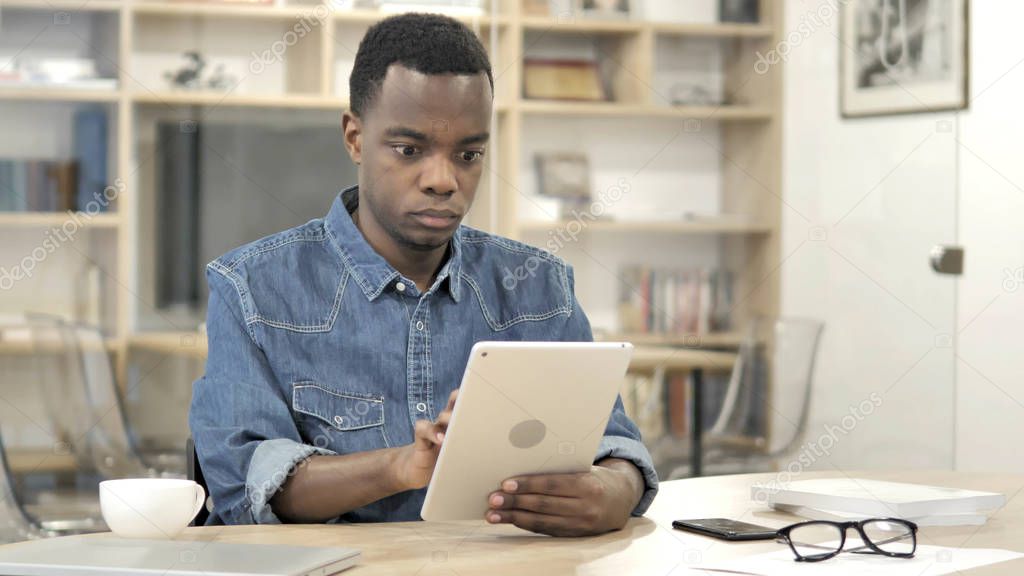 Young African Man Using Tablet in Office