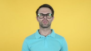 Genç Adam Gesturing Sessizlik, Dudaklar Parmak, Sarı Arka Plan