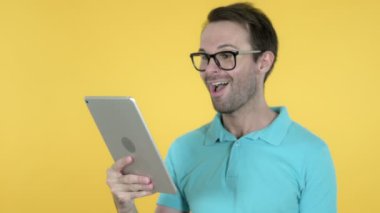 Tablet Ile Genç Adam tarafından Video Sohbet Sarı Arka Plan Izole