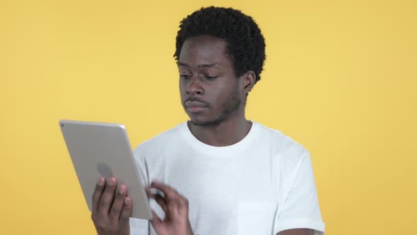 Homem Africano jovem animado para o sucesso ao usar Tablet isolado em fundo amarelo — Vídeo de Stock