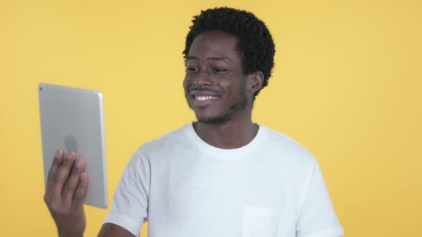 Video Chat by Young African Man via Tablet Isolado no fundo amarelo — Vídeo de Stock