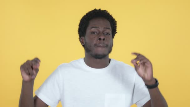 黄色の背景に孤立した若いアフリカ人男性が歌い、踊る — ストック動画