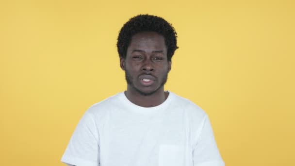 Hombre joven africano con dolor de cuello, fondo amarillo — Vídeo de stock
