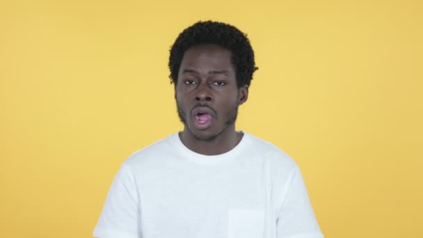 Esneyen Genç Afrikalı Adam Sarı Arka Plan Üzerinde İzole — Stok video