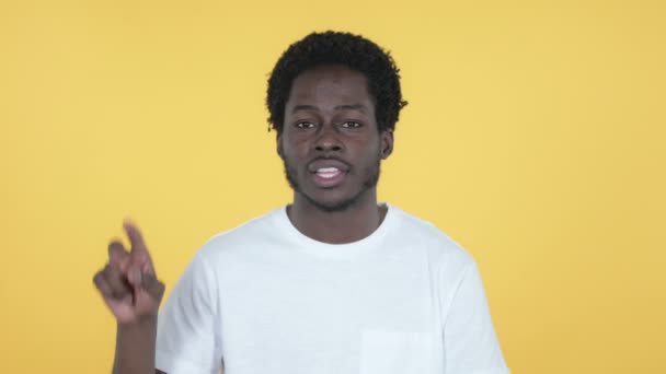 Győzelem jele az afrikai fiatalember, elszigetelt, a sárga háttér — Stock videók